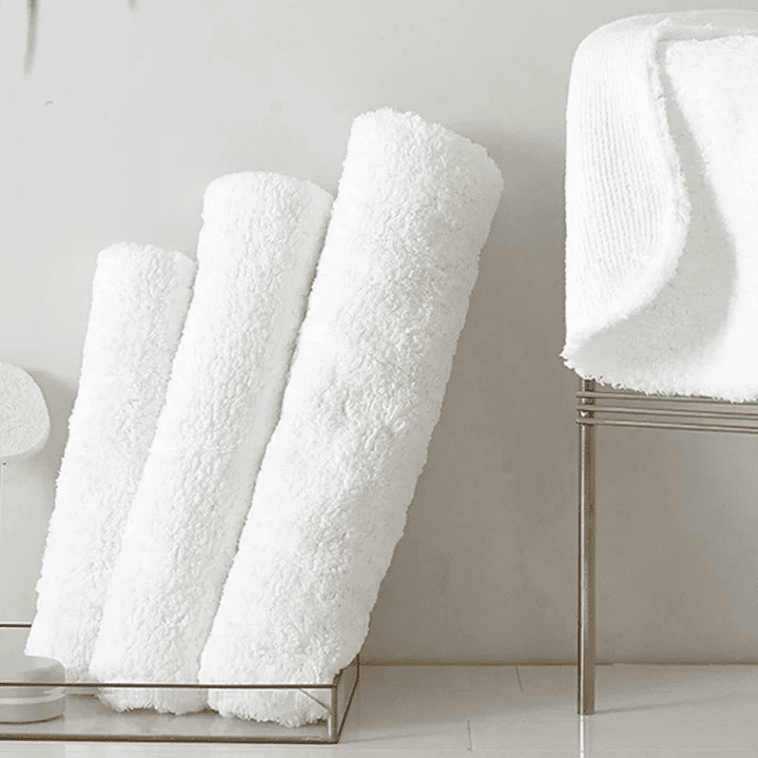 tapis de bain blanc coton avec serviettes roulées