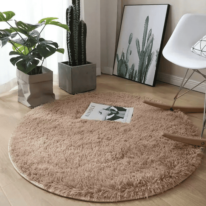 Tapis salon rond beige 160 cm au toucher moelleux, parfait pour créer une ambiance cocooning et harmonieuse.