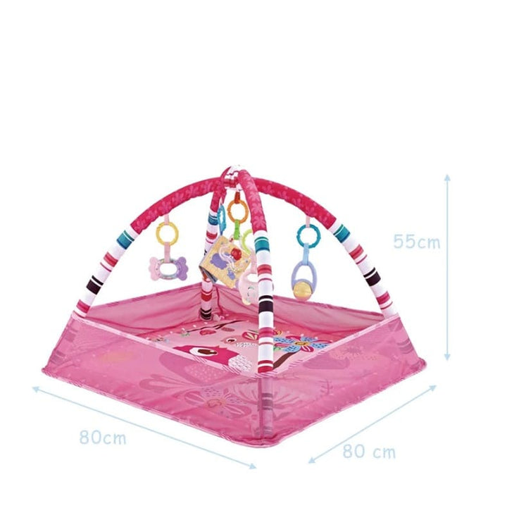 Tapis d’éveil pour bébé rose 80 × 80 cm (hauteur 55 cm) avec dimensions visibles, arche rayée multicolore et jouets suspendus.