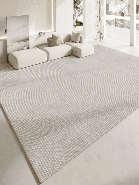 Tapis salon rectangulaire beige à motifs discrets, placé dans un salon lumineux au style contemporain, avec canapé blanc cassé.