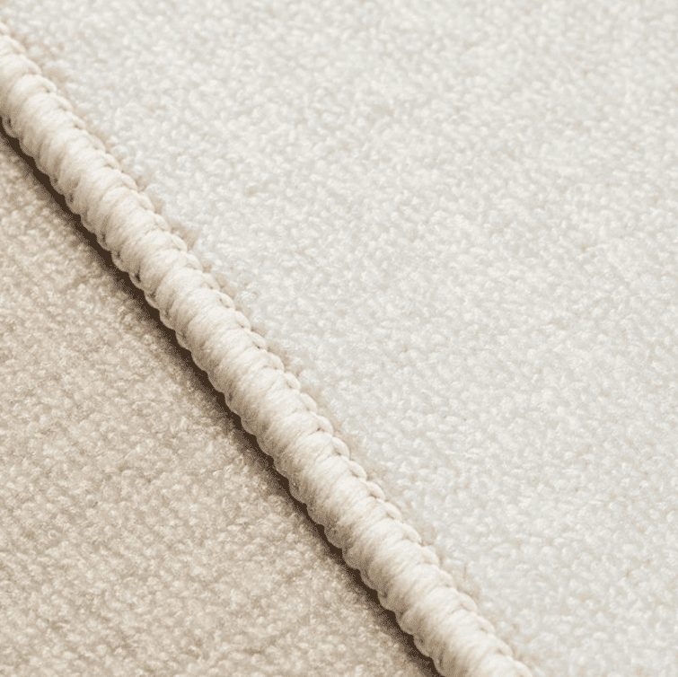 Gros plan sur la texture du tapis salon moutarde montrant son tissu doux, sa finition soignée et son aspect confortable.