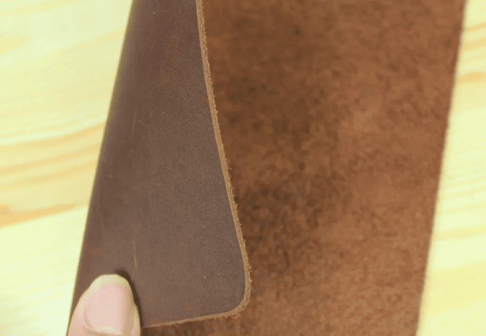 Détail du cuir naturel marron montrant la texture authentique du tapis de souris cuir