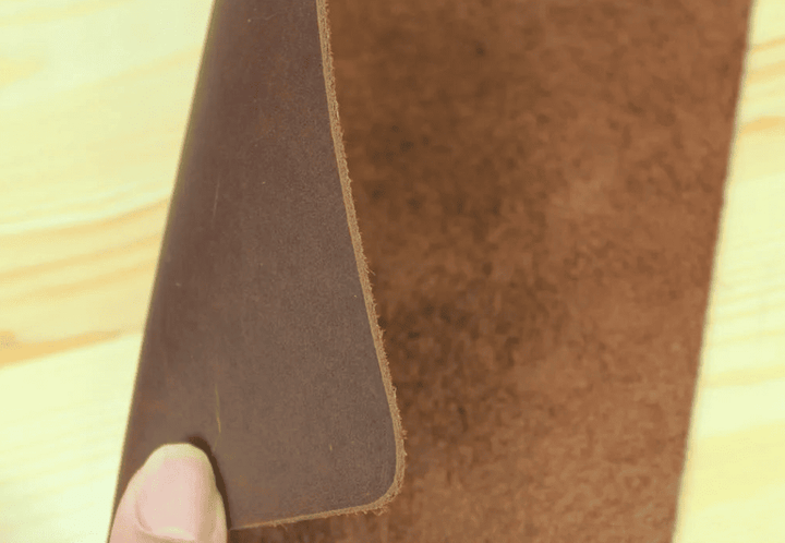 Détail du cuir naturel marron montrant la texture authentique du tapis de souris cuir