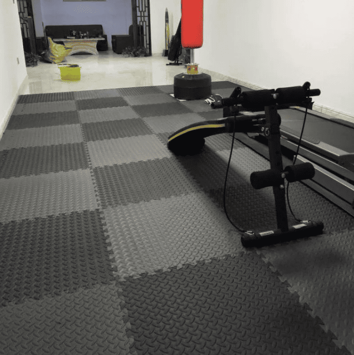 Vue d’une salle de sport maison équipée de dalles puzzle EVA noires et grises formant un sol antidérapant