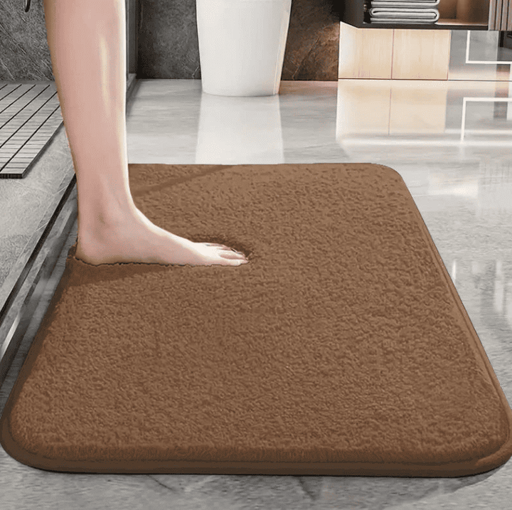 tapis de bain marron doux et absorbant utilisé après la douche