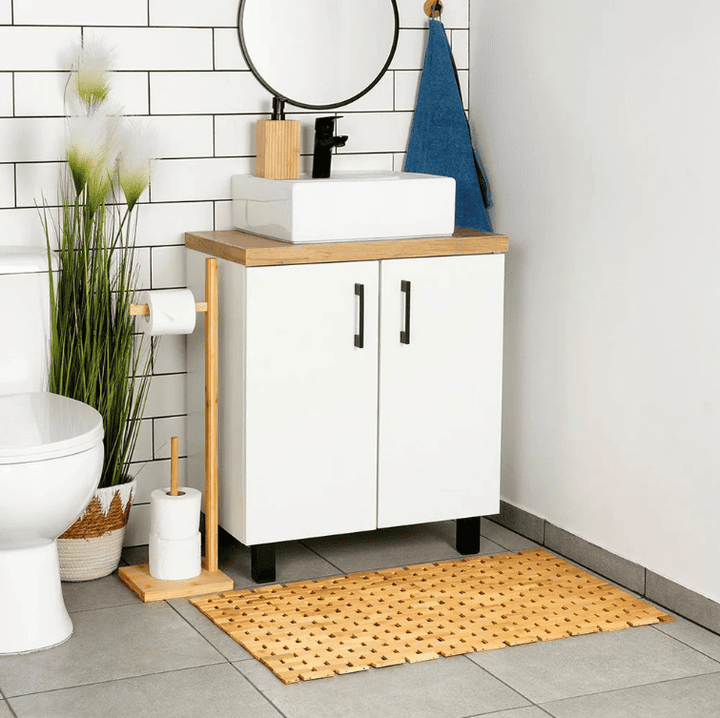 tapis de bain en bambou naturel devant un meuble de salle de bain style moderne et zen