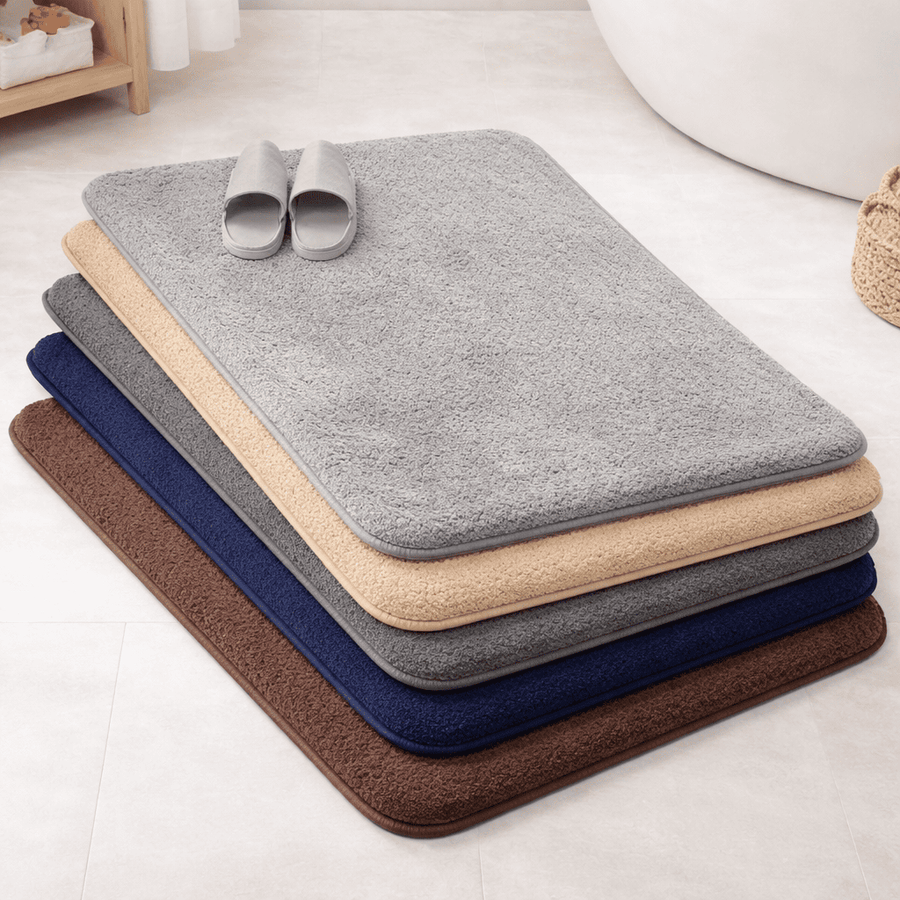 tapis de bain absorbant et antidérapant en plusieurs couleurs empilés dans une salle de bain moderne