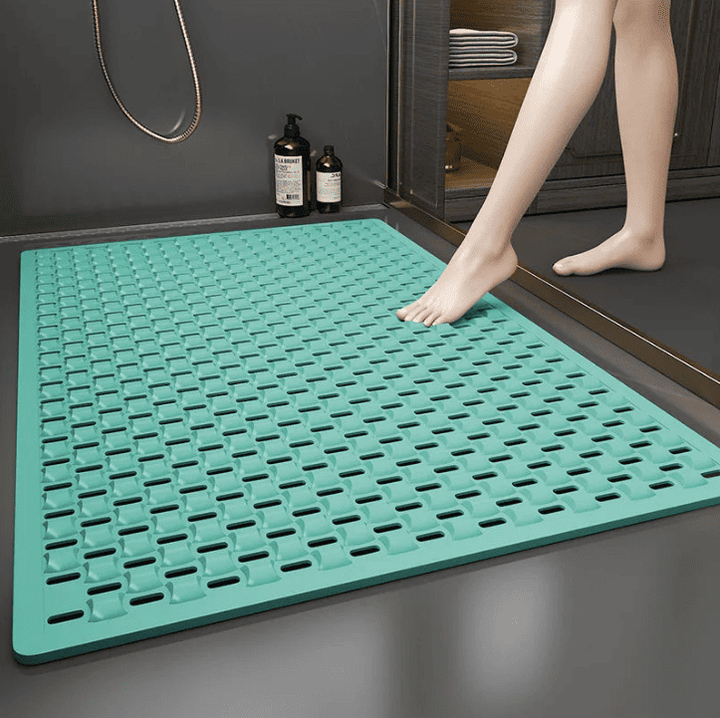 Tapis de bain antidérapant grand format couleur menthe, posé devant la douche pour offrir une surface sécurisée et drainée, idéal pour prévenir les chutes des seniors.