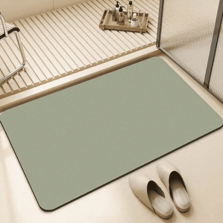 tapis de bain vert antidérapant posé dans une salle de bain moderne avec sol sec et sécurisé