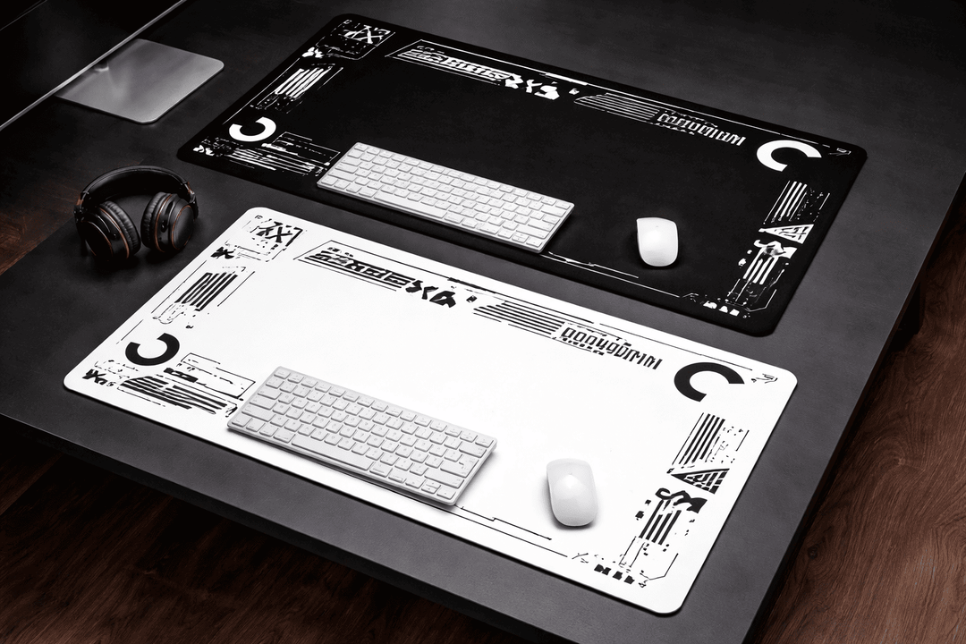 Deux tapis de souris 900x400 noir et blanc installés sur un bureau avec clavier et souris