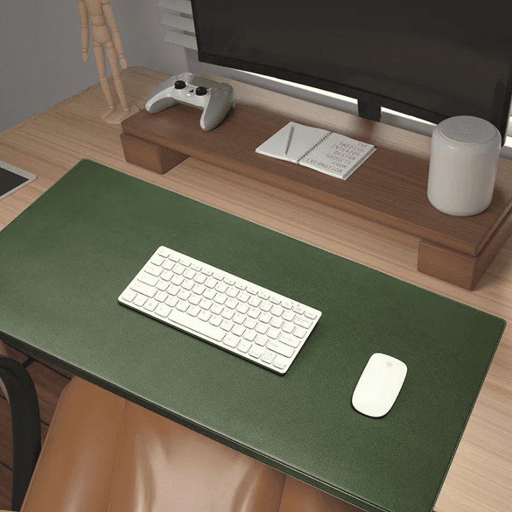 Tapis de souris vert XXL en similicuir posé sur un bureau en bois avec un clavier blanc et une souris