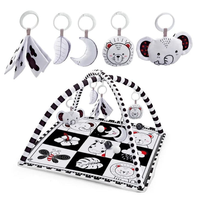 Tapis d’éveil noir et blanc pour bébé avec motifs contrastés, arche de jeux et peluches suspendues pour stimuler les sens dès la naissance.