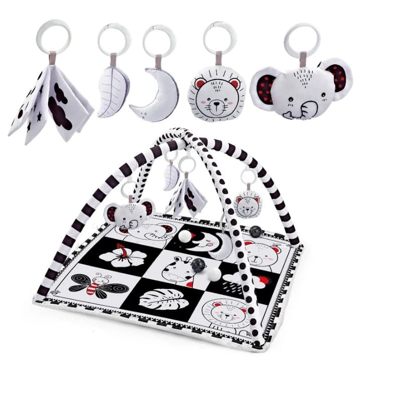Tapis d’éveil noir et blanc pour bébé avec motifs contrastés, arche de jeux et peluches suspendues pour stimuler les sens dès la naissance.