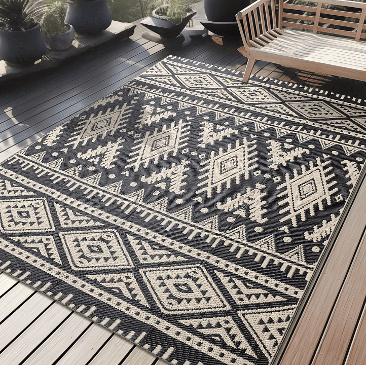 Tapis extérieur en plastique motif ethnique beige et noir, antidérapant et résistant pour terrasse ou balcon.