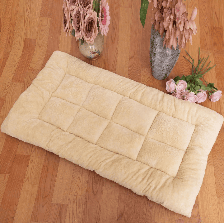 Grand tapis moelleux pour chien XXL beige posé sur parquet, entouré de bouquets de fleurs décoratives.