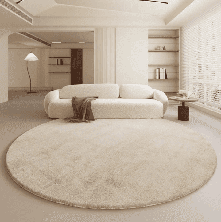 Salon moderne avec tapis rond beige de 120 cm devant un canapé crème et une table d’appoint, ambiance épurée et lumineuse.