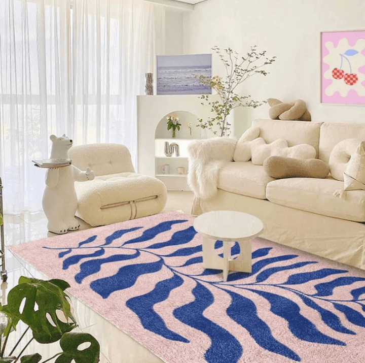 Tapis rose et bleu moderne avec motif artistique, apportant style et élégance dans un salon lumineux et contemporain.