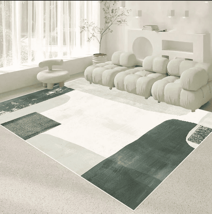 Tapis salon 160×230 cm motif abstrait vert foncé et vert clair sur fond crème, installé sous un canapé modulable dans un espace lumineux.