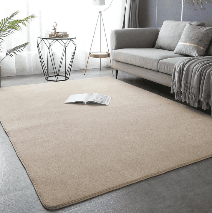 Grand tapis XXL beige dans un salon moderne avec canapé gris