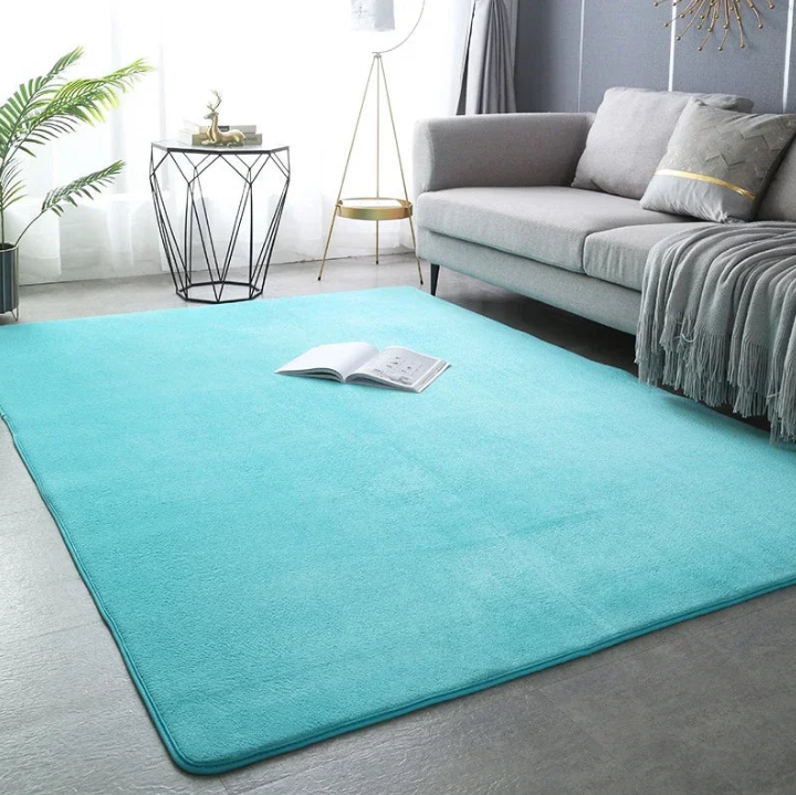 Grand tapis XXL turquoise dans un salon lumineux avec canapé gris clair