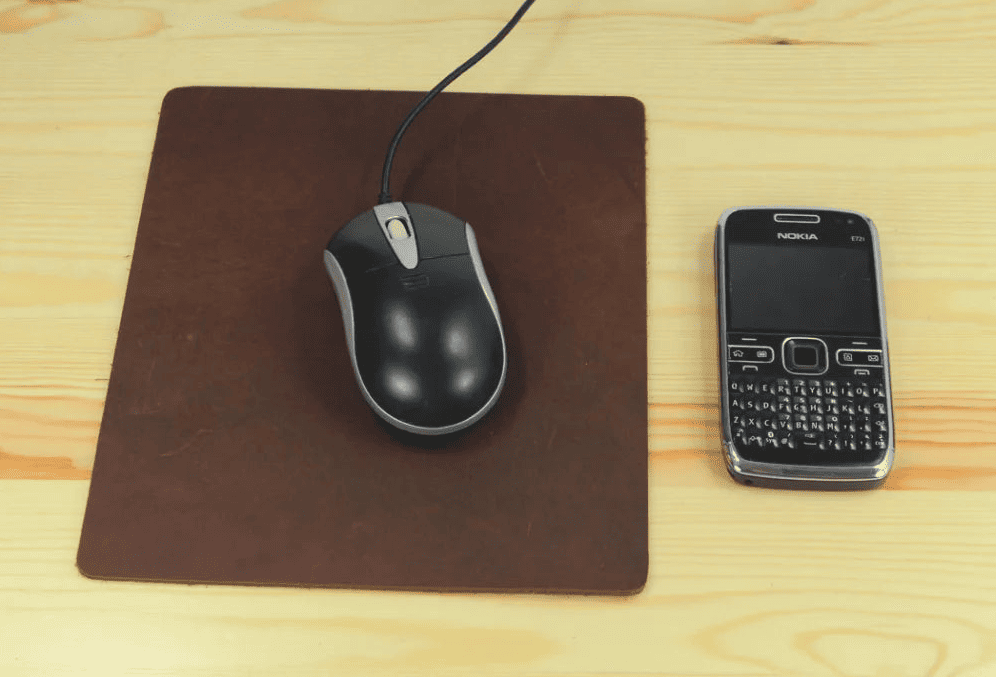Tapis de souris cuir marron format compact 21,5 x 18,5 cm avec souris et téléphone pour comparaison
