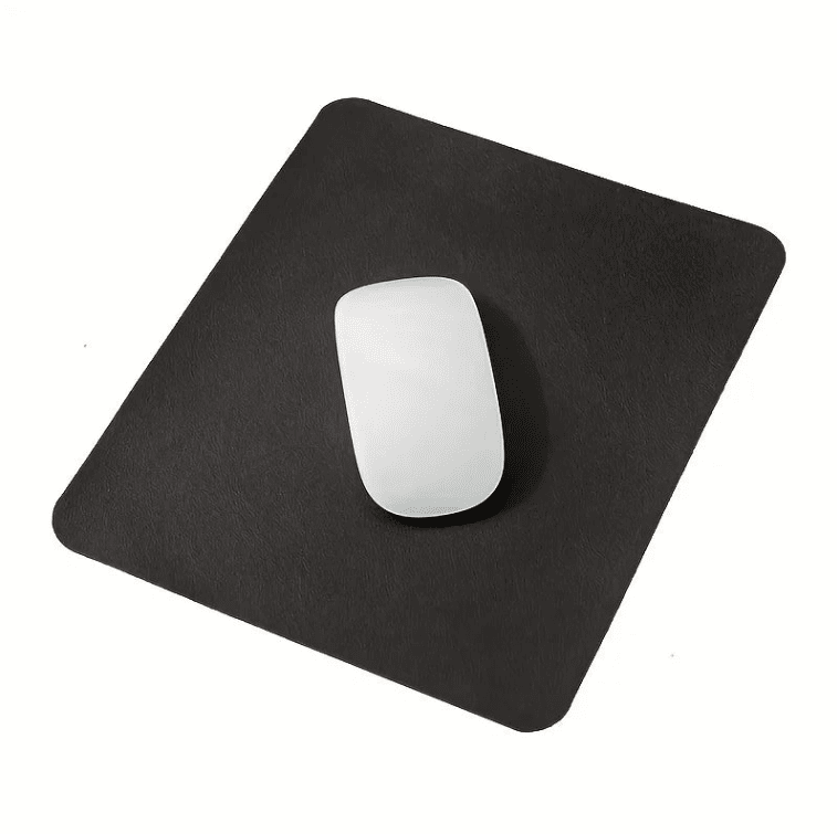 Tapis de souris cuir noir avec souris blanche posé sur un bureau