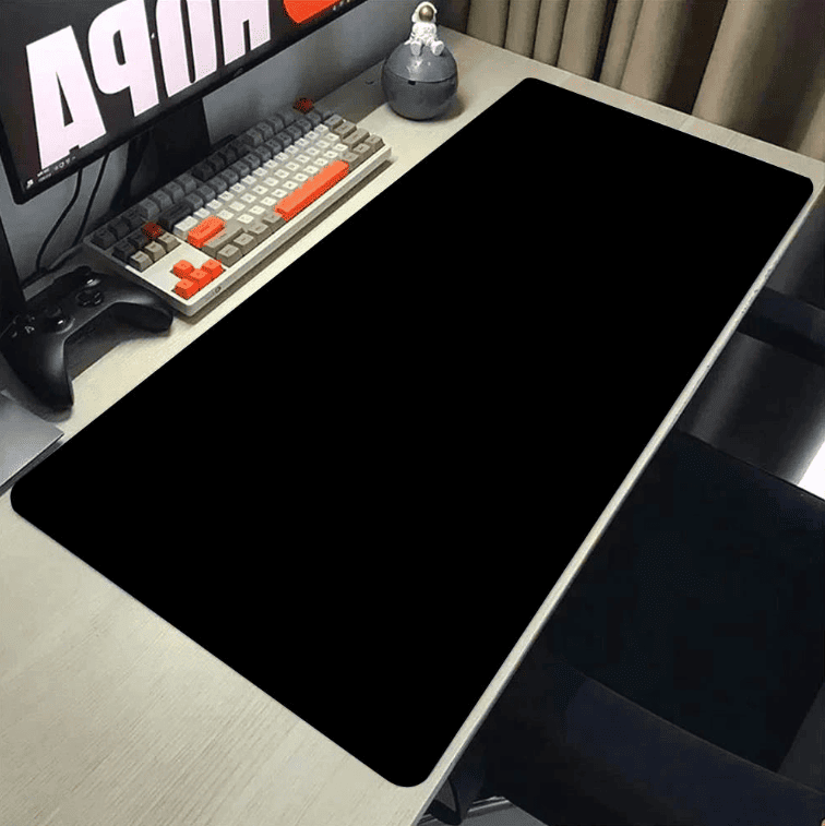 tapis de souris noir installé sur bureau avec clavier et souris
