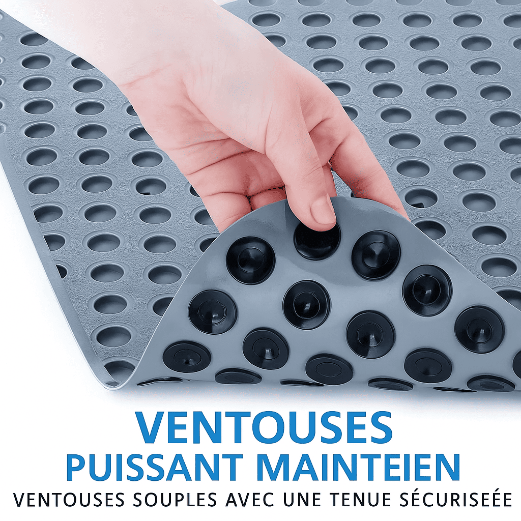 Gros plan sur une main soulevant un tapis de baignoire pour montrer les ventouses flexibles noires situées en dessous, assurant une adhérence maximale pour éviter les glissades.